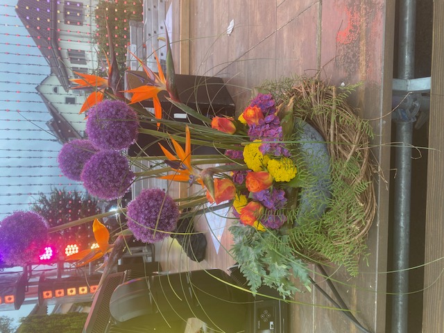 Exotisches Blumenarrangement mit Alium und Paradiesvogelblumen auf der Bühne